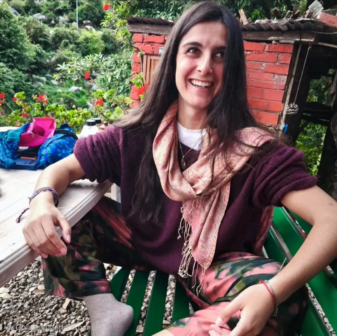 Lauriane souriante, assise en extérieur au milieu de la végétation