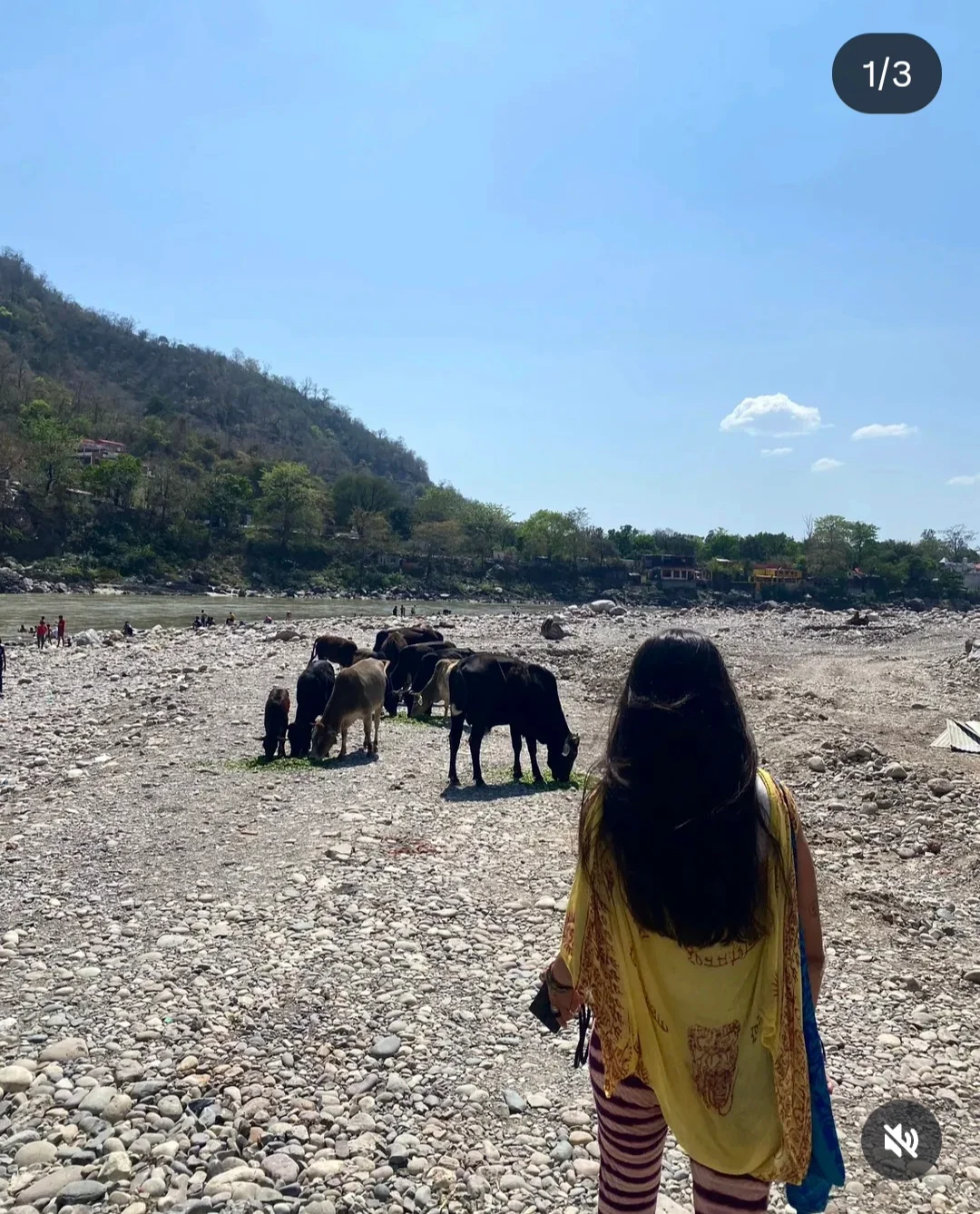 Lauriane de dos, sur une rive de galets en Inde, face au fleuve et aux collines